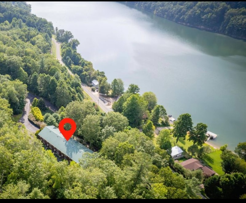 Aerial view of the property with Watauga Lake in the background and forest cover all around.